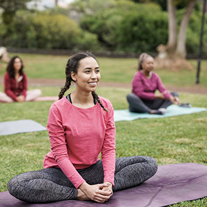 Woman doing yoga outside with friends
