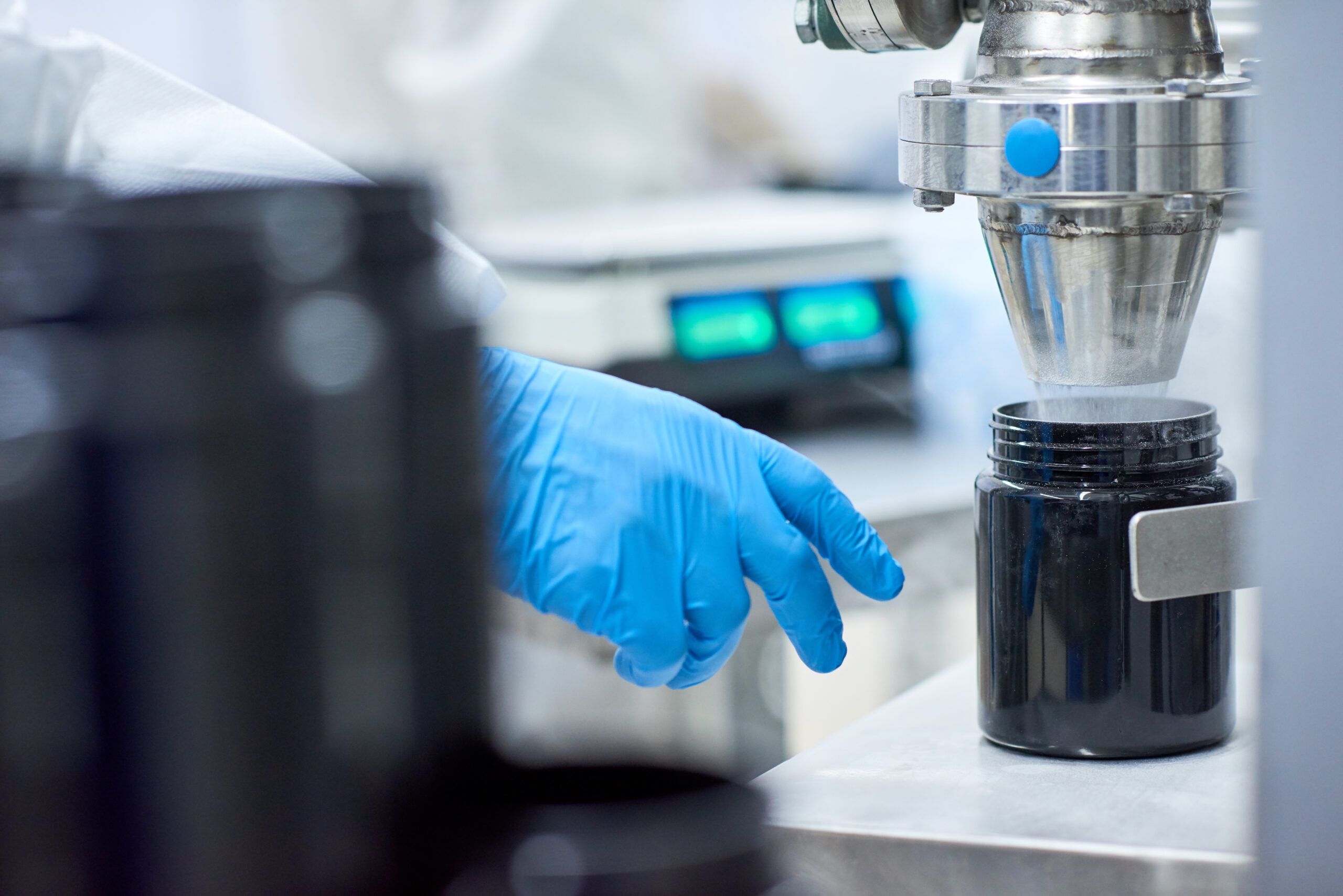 Factory employee filling plastic jar with product